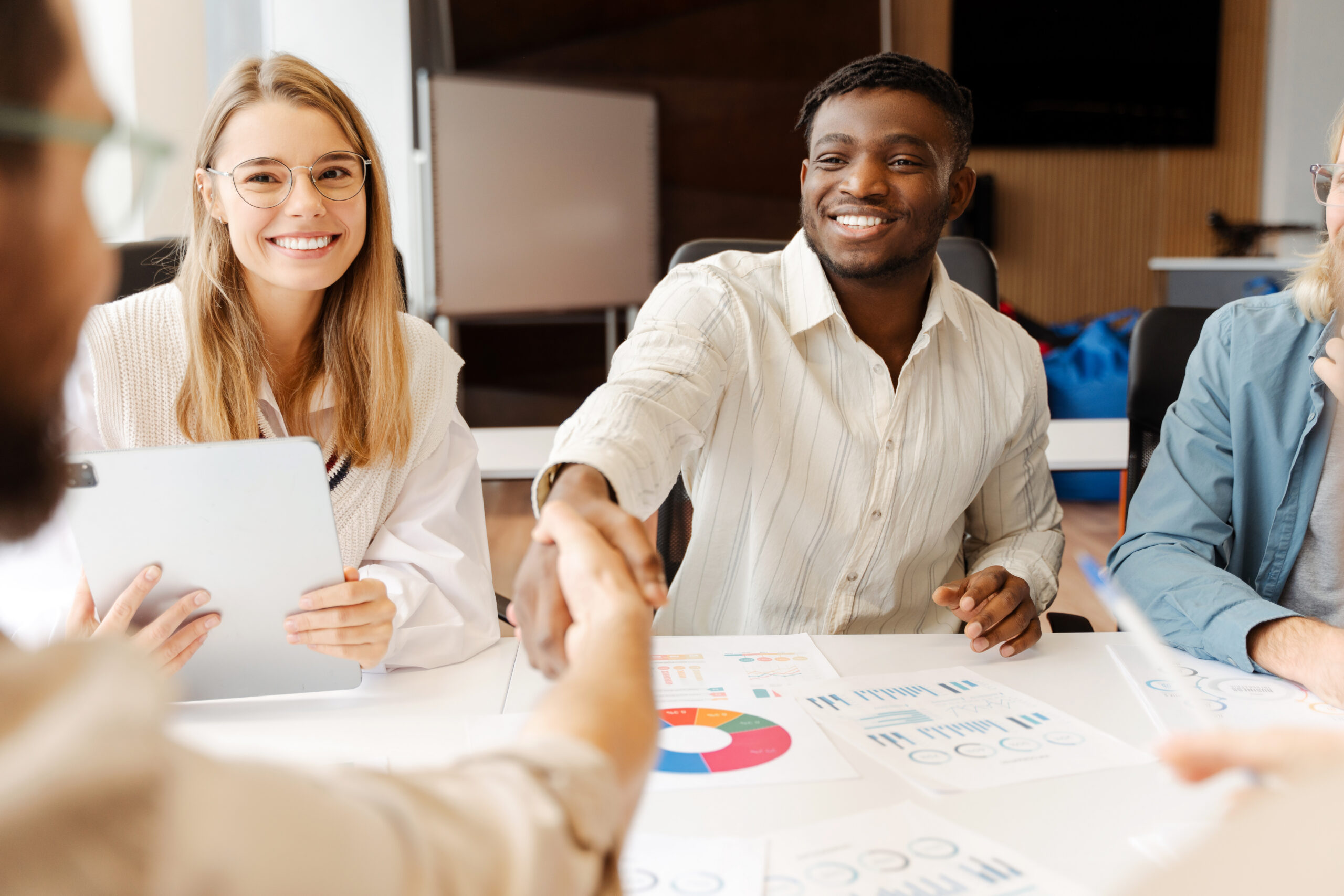 Business professionals shaking hands after a meeting, representing customer acquisition strategies.