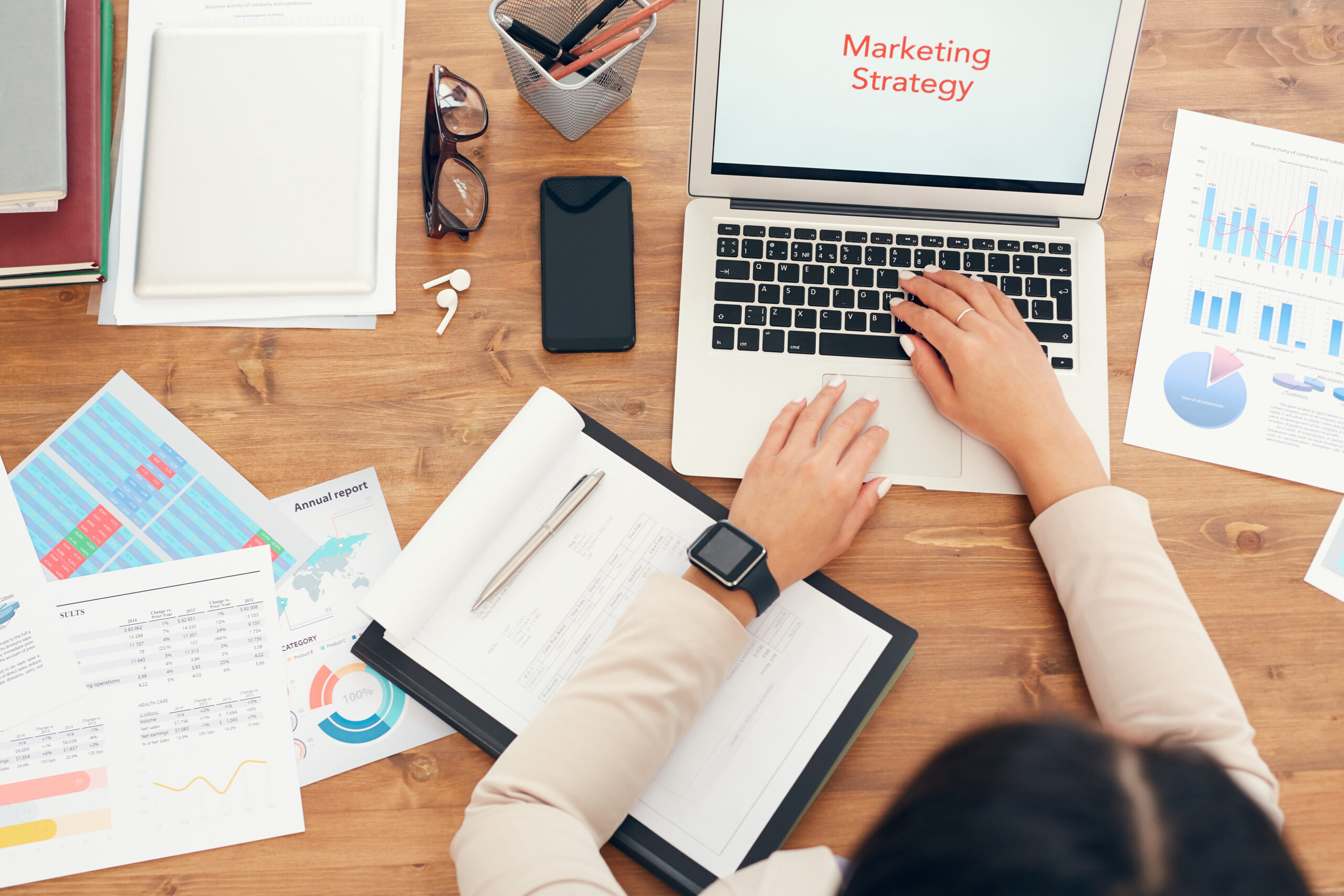A professional analyzing data and reports on a laptop, developing effective marketing strategies for business growth.